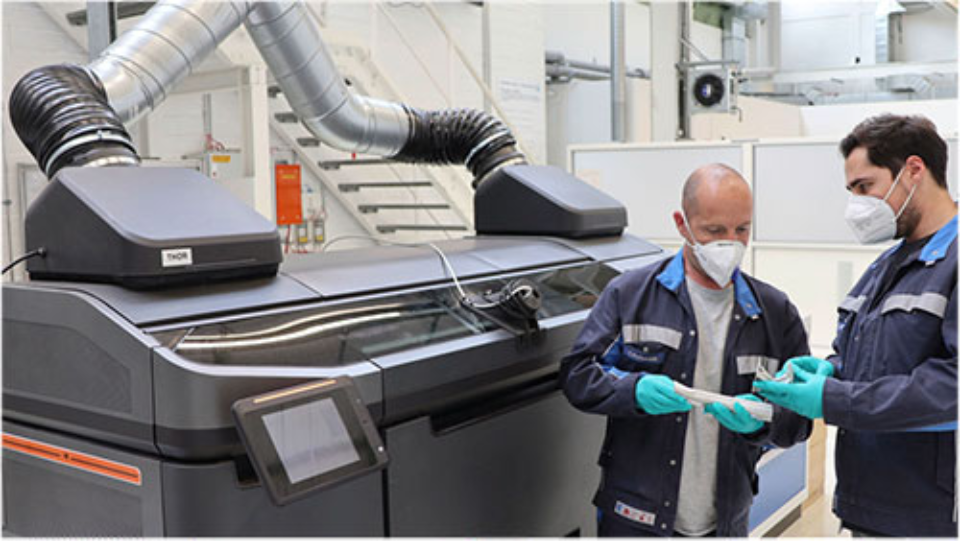 In 3D và xu hướng phát triển mạnh mẽ trong ngành điện tử 35 Hai nhân viên của Volkswagen kiểm tra chất lượng của các bộ phận kết cấu được sản xuất bằng quy trình phun chất kết dính dành cho sản xuất ô tô trước nguyên mẫu của máy in đặc biệt tại trung tâm in 3D công nghệ cao ở Wolfsburg